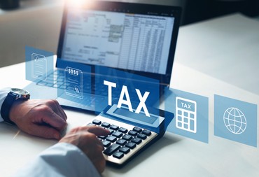Tax and Vat concept. Businessman using the laptop to fill in the income tax online return form for payment. Financial research,government taxes and calculation tax return concept.